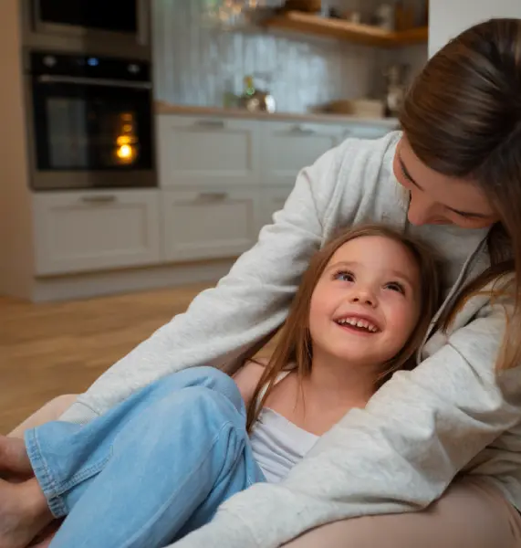 A happy mother and young daughter smiling together, representing the strong parental bonds protected by a top-rated move-away attorney in Orange County.